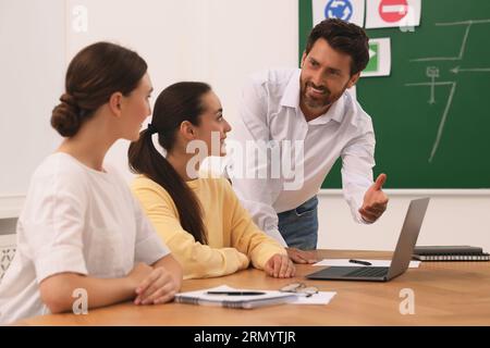 Happy teacher giving lesson in driving school Stock Photo