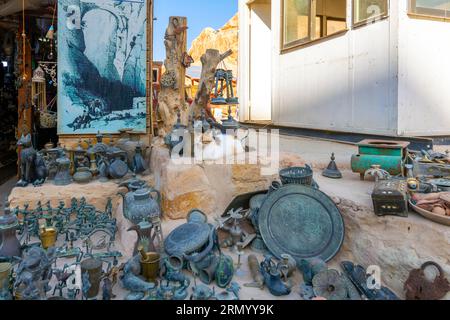 A long hair cat sleeps among souvenir collectibles and trinkets at the entrance to the ancient city of Petra, Jordan. Stock Photo