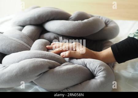 women hand over a gray color pillow on white bed  Stock Photo
