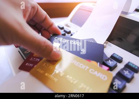 Hand holding credit card with printing calculator on table, black credit card mock in human hand, The concept of financial operations and credit card Stock Photo