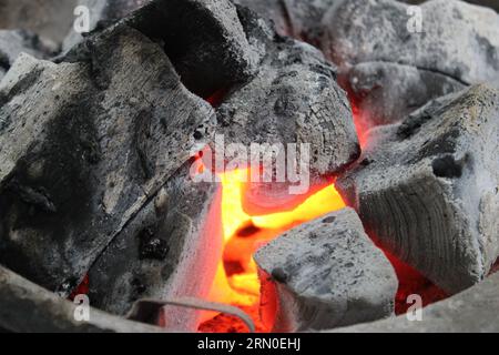 Fire burning among hot coals, in barbecue grill Stock Photo