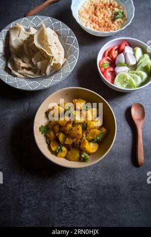 Aloo jeera or potato masala served with Indian flat bread and salad. Stock Photo