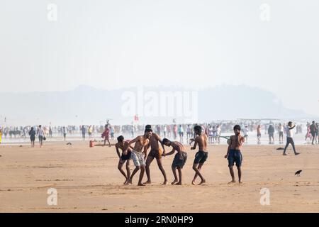 Calangute, Goa, India - January 2023:A group of young Indian men playing and having fun on the beach. Stock Photo