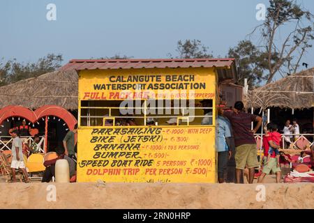 Calangute, Goa, India - January 2023: Rates for water sports advertised on the yellow wall of the Calangute Water Sports Association kiosk on Calangut Stock Photo
