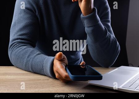 Biracial businessman using smartphone and laptop on grey background Stock Photo
