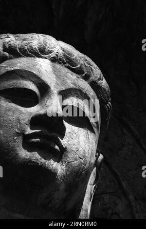 A close-up shot of The statue of Buddha from the Tang Dynasty of China, carved 1500 years ago, Stock Photo