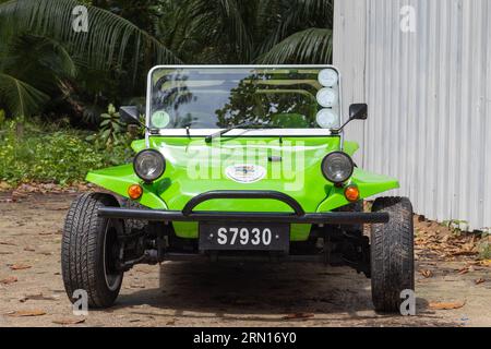 Mahe, Seychelles - August 7, 2023: Front view of a green black beach buggy standing parked on a sunny day Stock Photo