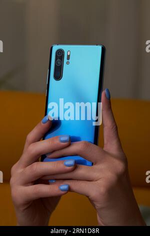 Womans hands is using smartphone, writing a message, browsing social networks. Technologies for life and work. Stock Photo