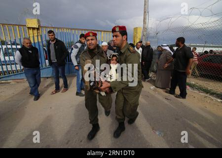 Members of the Palestinian security forces carry a girl, who needs to receive medical treatment outside Gaza, as she waits to cross into Egypt at the Rafah crossing between Egypt and the southern Gaza Strip, Dec. 21, 2014. Egypt temporarily reopened the Rafah border crossing on Sunday allowing Palestinians from Gaza Strip to travel in and out for the first time since it was closed on Oct. 25, officials in Gaza said. Egypt closed Rafah crossing following a series of deadly attacks carried out by radical Islamic militants in Sinai. After the attacks, the Egyptian army carried out the largest eve Stock Photo