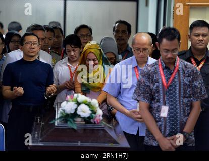 AKTUELLES ZEITGESCHEHEN Absturz von AirAsia-Flug QZ8501 - Angehörige trauern (150101) -- SURABAYA, Jan. 1, 2015 -- People stand in silent tribute during the hand over ceremony in Surabaya, on Jan. 1, 2015. Experts identifying victims of the AirAsia plane that sank in Indonesia s water announced the first result of their works to identify two bodies on Thursday, saying they were to hand one of them to her family soon. Head of Disaster Victim Identification (DVI) named only Budiono said that one of the two bodies was successfully identified to be an Indonesian woman named Hayati Lutfiah Hamid fr Stock Photo
