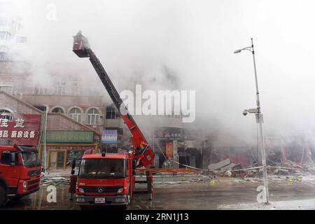 (150104) -- HARBIN, Jan. 4, 2015 -- Smokes rise from a burnt warehouse at the Beifangnanxun ceramics market in Daowai District, Harbin, capital of northeast China s Heilongjiang Province, Jan. 4, 2014. The warehouse blaze in Harbin City that killed 5 firefighters still hasn t been completely extinguished, local firefighters said on Sunday. As of 10:40 a.m. Sunday, a residential building next to the warehouse was still smoldering. Rescuers said that the source of the fire has been hard to determine due to the building s complicated structure, and the building is at risk of collapsing. Firefight Stock Photo