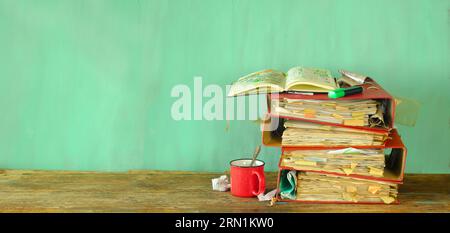 messy file folders,red tape, bureaucracy,aministration,business, messy office concept.Isolated on green background. Stock Photo