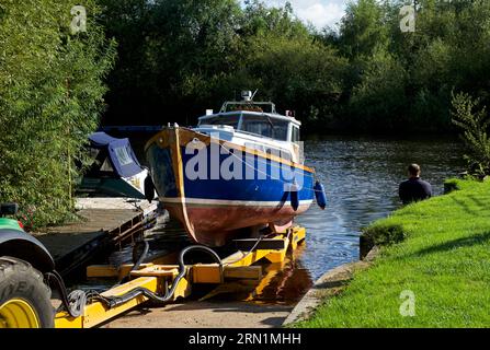 Boat being launched, by tractor, onto the River Ouse, at Acaster Maine, Acaster Malbis, North Yorkshire, England UK Stock Photo
