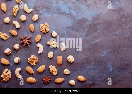 Aesthetic repeated pattern with assorted nuts on rustic background. Hazelnuts , walnuts, almonds, cashews. Healthy snacks and desserts. Copy space. Stock Photo