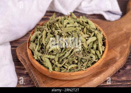 Dried balm tea. Sun-dried lemon balm tea leaves in wood bowl. herbal medicine Stock Photo