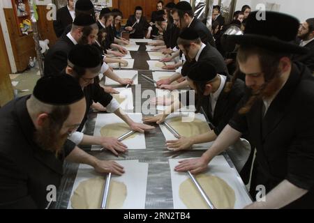 (150323) -- RECHOVOT (ISRAEL), March 23, 2015 -- Ultra-Orthodox Jews make matzo for the upcoming Jewish holiday of Passover at a bakery in Rechovot, central Israel, on March 23, 2015. Matzo is an unleavened bread traditionally eaten by Jews during the week-long Passover holiday, when eating chametz, bread and other food made with leavened grain, is forbidden according to Jewish religious law. Passover is an important Biblically-derived Jewish festival. The Jewish people celebrate Passover as a commemoration of their liberation over 3,300 years ago by God from slavery in ancient Egypt that was Stock Photo