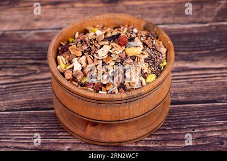 Dried winter tea. Sun-dried winter tea leaves in wood bowl. Winter tea prepared with granulated apple, lemon, orange, ginger, galangal, melissa, rosem Stock Photo