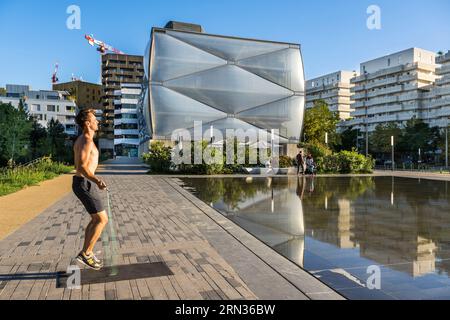 France, Herault, Montpellier, Port Marianne district, Le Nuage building by designer Philippe Starck, sportsman jumping rope in front of the water mirror in the foreground on avenue Raymond Dugrand Stock Photo