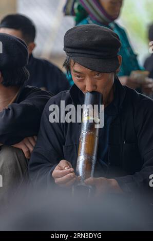 Vietnam, Ha Giang, Xa Phin market, portrait of a man of ethnic minority group of Black Hmongs smoking pipe Stock Photo