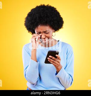 Sad, fraud and woman with phone scam and identity theft problem and tech in studio. Stress, mobile error and confused from phishing, hacking and Stock Photo