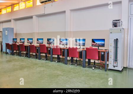 empty computer lab in a university. Computer lab room. room with a lot of computers, desks, chairs, and keyboards. Stock Photo