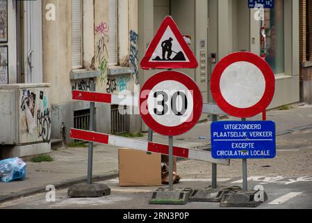 A roadblock with signs for safety preventing cars to enter the road. Only local vehicles are allowed. Stock Photo