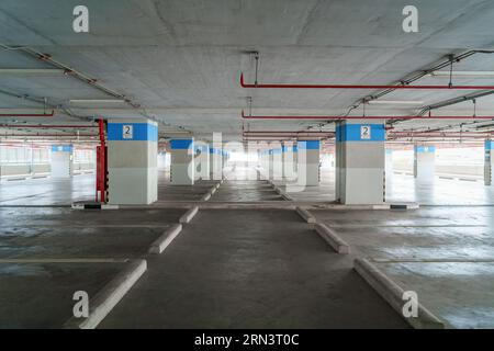 An empty parking garage stands as a cavernous space, waiting to welcome vehicles and providing ample room for convenience and organization. Stock Photo