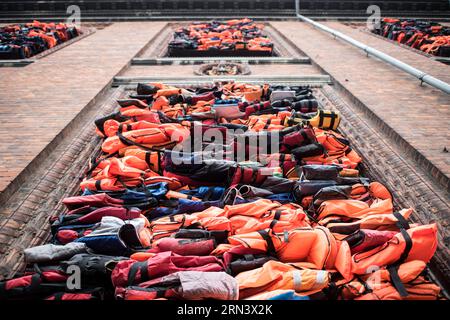 COPENHAGEN, Denmark — A large art installation by Ai Weiwei titled Soleil Levant on the facade of Kunsthal Charlottenborg on the waterfront of Copenhagen's harbor. The piece consists of a barricade of the building's windows with more than 3500 life jackets collected from refugees on the Greek island of Lesbos. It was unveiled on UN International Refugee Day on June 20, 2017, and remained in place until the beginning of October 2017. Kunsthal Charlottenborg is the official exhibition gallery of the Royal Danish Academy of Art. Stock Photo