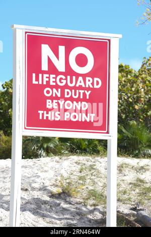 A sign on the beach that says 'No lifeguards on duty'. Stock Photo