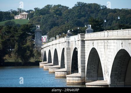 WASHINGTON DC, United States — Arlington Memorial Bridge stretches across the Potomac River, offering a direct view towards Arlington House in Arlington National Cemetery. The neoclassical bridge connects Washington DC to Virginia and is a key architectural landmark in the nation's capital. Arlington House, seen in the distance, stands atop a hill overlooking the cemetery and the city beyond. Stock Photo