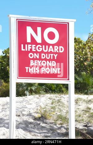 A sign on the beach that says 'No lifeguards on duty'. Stock Photo