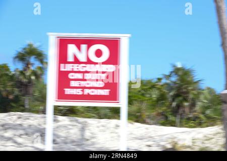 A sign on the beach that says 'No lifeguards on duty'. Stock Photo