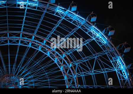 ORLANDO, Florida, United States — The Orlando Eye, now known as The Wheel at Icon Park, illuminates the night sky in Orlando, Florida. Standing 400 feet tall, this observation wheel offers panoramic views of the city and surrounding attractions. The colorful LED lights create a striking visual display against the dark sky. Stock Photo