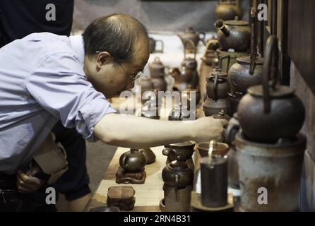 (150515) -- KUNMING, May 15, 2015 -- A visitor chooses tea sets during the 10th China Yunnan Pu er Tea Expo in Kunming, capital of southwest China s Yunnan Province, May 15, 2015. The four-day tea expo, kicked off in Kunming on Friday, attracting over 400 tea companies. ) (yxb) CHINA-KUNMING-PU ER TEA EXPO (CN) LyuxShuai PUBLICATIONxNOTxINxCHN   Kunming May 15 2015 a Visitor Chooses Tea Sets during The 10th China Yunnan Pu he Tea EXPO in Kunming Capital of Southwest China S Yunnan Province May 15 2015 The Four Day Tea EXPO kicked off in Kunming ON Friday Attracting Over 400 Tea Companies yxb C Stock Photo