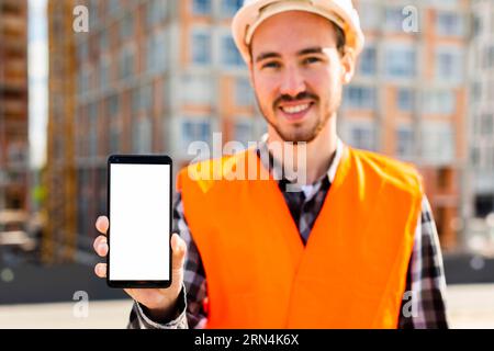Medium shot portrait construction engineer holding phone Stock Photo