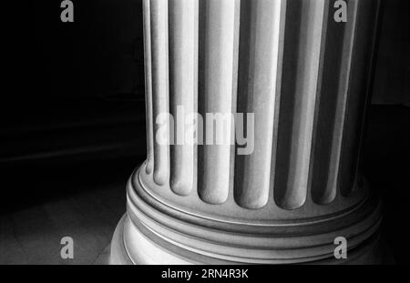 Column Base Detail, Lincoln Memorial, National Mall, Washington DC — Black and White Photo | WASHINGTON D.C., United States — A close-up of a fluted Doric column base at the Lincoln Memorial, rendered in black and white with dramatic contrast between light and shadow. Architect Henry Bacon completed the memorial in 1922, and its colonnade of 36 Doric columns represents the 36 states of the Union at the time of Abraham Lincoln's death. Stock Photo