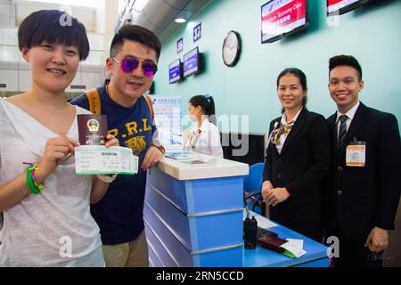 Passengers (L) leaving for Guangzhou, capital of south China s Guangdong Province, pose for a photo beside a check-in counter at Cam Ranh International Airport in Nha Trang City, central Vietnam s Khanh Hoa Province, June 20, 2015. China Southern Airlines on Saturday opened the direct flight between China s Guangzhou and Vietnam s Nha Trang. ) VIETNAM-NHA TRANG-CHINA S GUANGZHOU-DIRECT FLIGHT NguyenxLexHuyen PUBLICATIONxNOTxINxCHN   Passengers l leaving for Guangzhou Capital of South China S Guangdong Province Pose for a Photo Beside a Check in Counter AT Cam Ranh International Airport in Nha Stock Photo