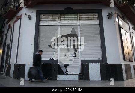 File photo taken on June 24, 2013 shows a man walking past a portrait of the tango singer Carlos Gardel in Buenos Aires, Argentina. People commemorate the 80th death anniversary of Carlos Gardel on Wednesday. Carlos Gardel was a singer, songwriter, composer and actor, and the most prominent tango figure in the first half of 20th century. For many, Gardel embodies the soul of tango style. Gardel died in an airplane crash at the height of his carrer, becoming an archetypal tragic hero mounrned throughout Latin America. )(zhf) ARGENTINA-BUENOS AIRES-MUSIC-GARDEL-ANNIVERSARY MartInxZabala PUBLICAT Stock Photo