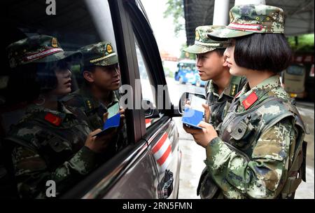 DEHONG, June 24, 2015 -- Zhang Liu (R) and her comrade check a car at the border checkpoint of Mukang in Dehong Dai-Jingpo Autonomous Prefecture, southwest China s Yunnan Province, June 24, 2015. Born in 1995, Zhang Liu became an anti-drug soldier in border checkpoint of Mukang in 2013. Grown up in an affluent family in central China s Hunan Province, Zhang said that being a soldier had always been her dream, which drove her to join the army after graduating from high school. Being a front line anti-drug force, the border checkpoint of Mukang has captured about 100 kilograms of drugs since the Stock Photo