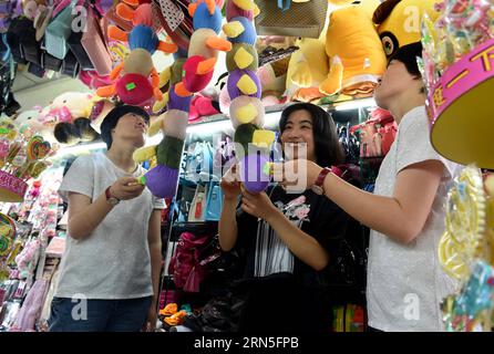DEHONG, June 24, 2015 -- Zhang Liu (C) and her comrades enjoy leisure time at a toy shop in Dehong Dai-Jingpo Autonomous Prefecture, southwest China s Yunnan Province, June 24, 2015. Born in 1995, Zhang Liu became an anti-drug soldier in border checkpoint of Mukang in 2013. Grown up in an affluent family in central China s Hunan Province, Zhang said that being a soldier had always been her dream, which drove her to join the army after graduating from high school. Being a front line anti-drug force, the border checkpoint of Mukang has captured about 100 kilograms of drugs since the beginning of Stock Photo