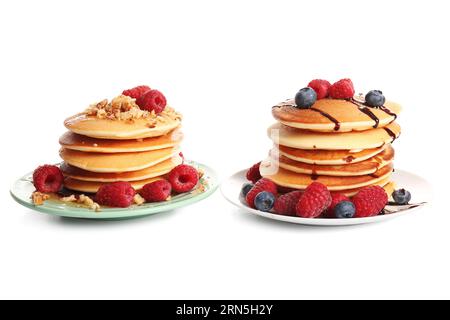 Plates of tasty pancakes with raspberries and blueberries isolated on white background Stock Photo