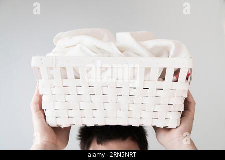 Front view person holding laundry basket head Stock Photo