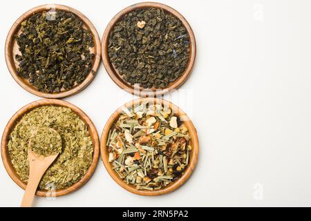 Assortment dry medicinal herbs wooden circular plates white backdrop Stock Photo