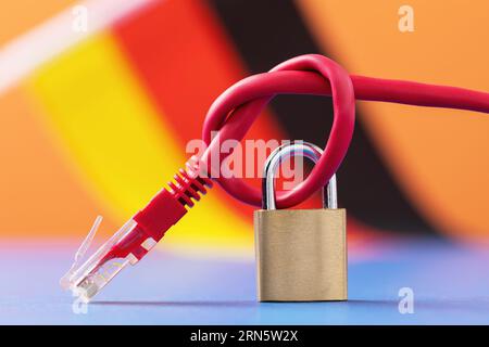 Closed lock on a knotted network wire against the background of the German flag, a concept on the topic of computer network security in Germany Stock Photo