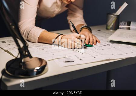 Crop woman making blueprints Stock Photo