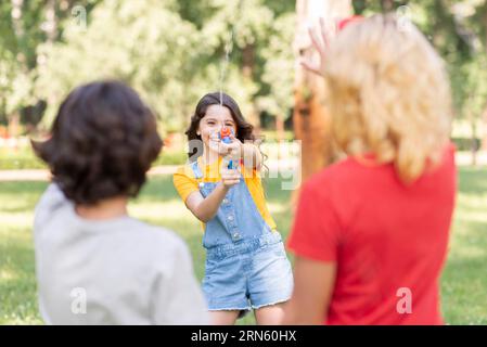 Childrens park playing with water gun Stock Photo