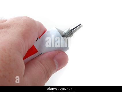 The hand holding glue tube isolated on white background Stock Photo