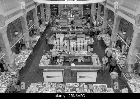 Black and white photo panorama of the hall from a bird's eye view of the stalls with crabs, octopus, fish and mussels, historical fish market Stock Photo