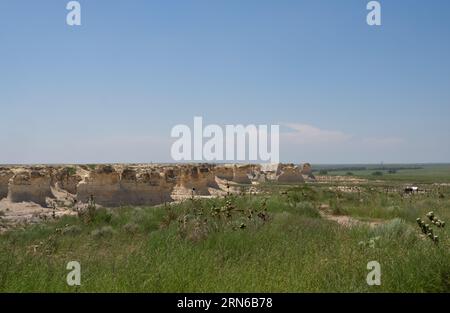 Little Jerusalem Badlands State Park in Kansas with its scenic overlook to the right and yucca plants and prairie grass in the foreground. Stock Photo