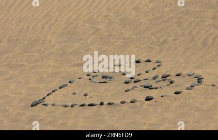 Corazón hecho con piedras en las dunas de Maspalomas. Gran Canaria, España Stock Photo